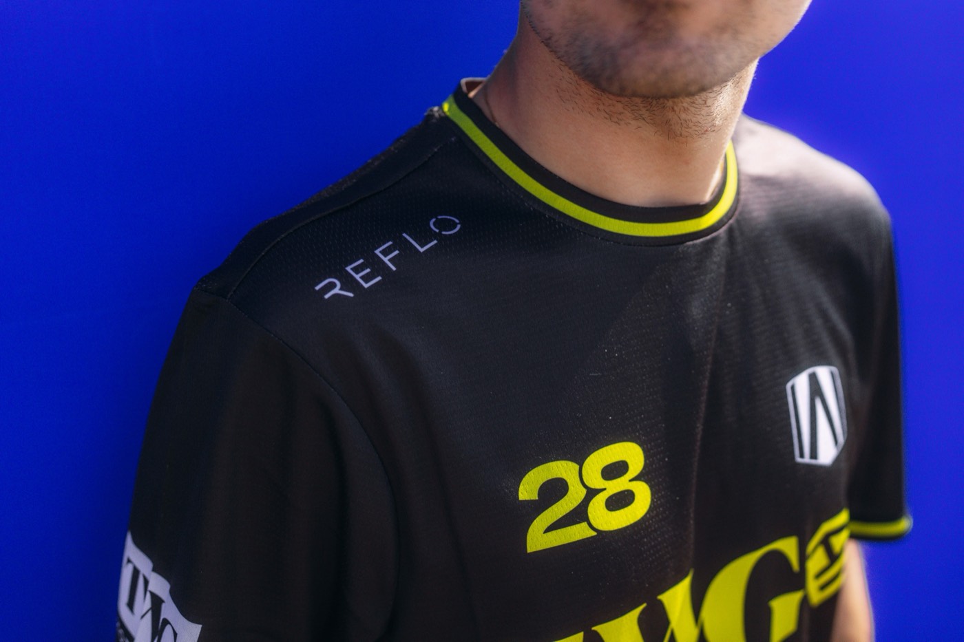 Close crop of a black and yellow race shirt with the number 28 and a Reflo logo at the shoulder